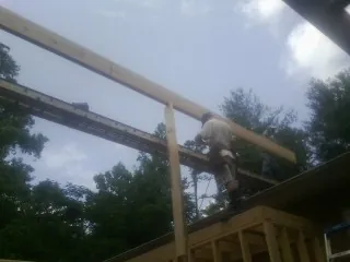 Carpenter setting a ridge beam over a new addition frame — Ice Dam Removal by Roofing Brothers in Henryetta