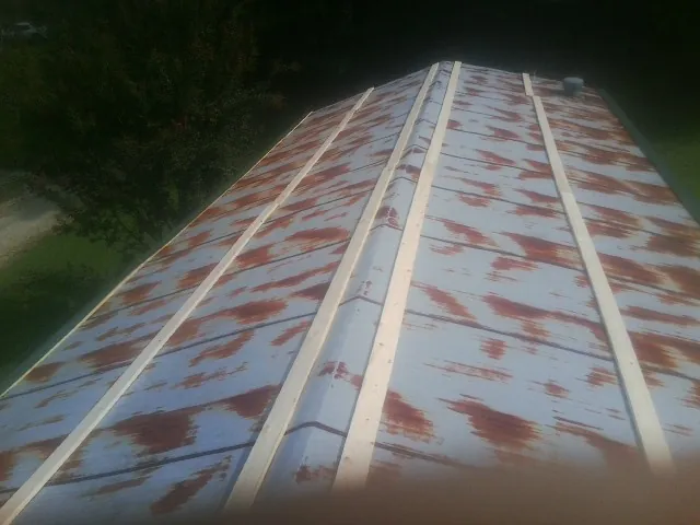 Rusted metal roof panels with new wood purlins before replacement — Storm Damage Roof Repair in Henryetta by Roofing Brothers