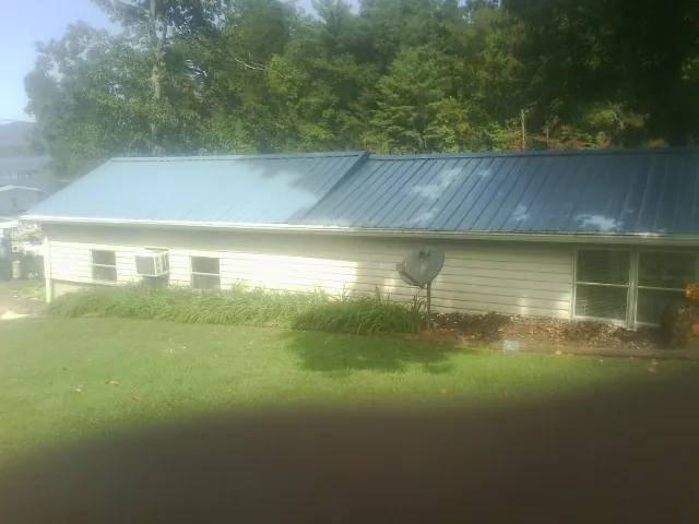 Blue metal roof running the length of a single story home in Henryetta