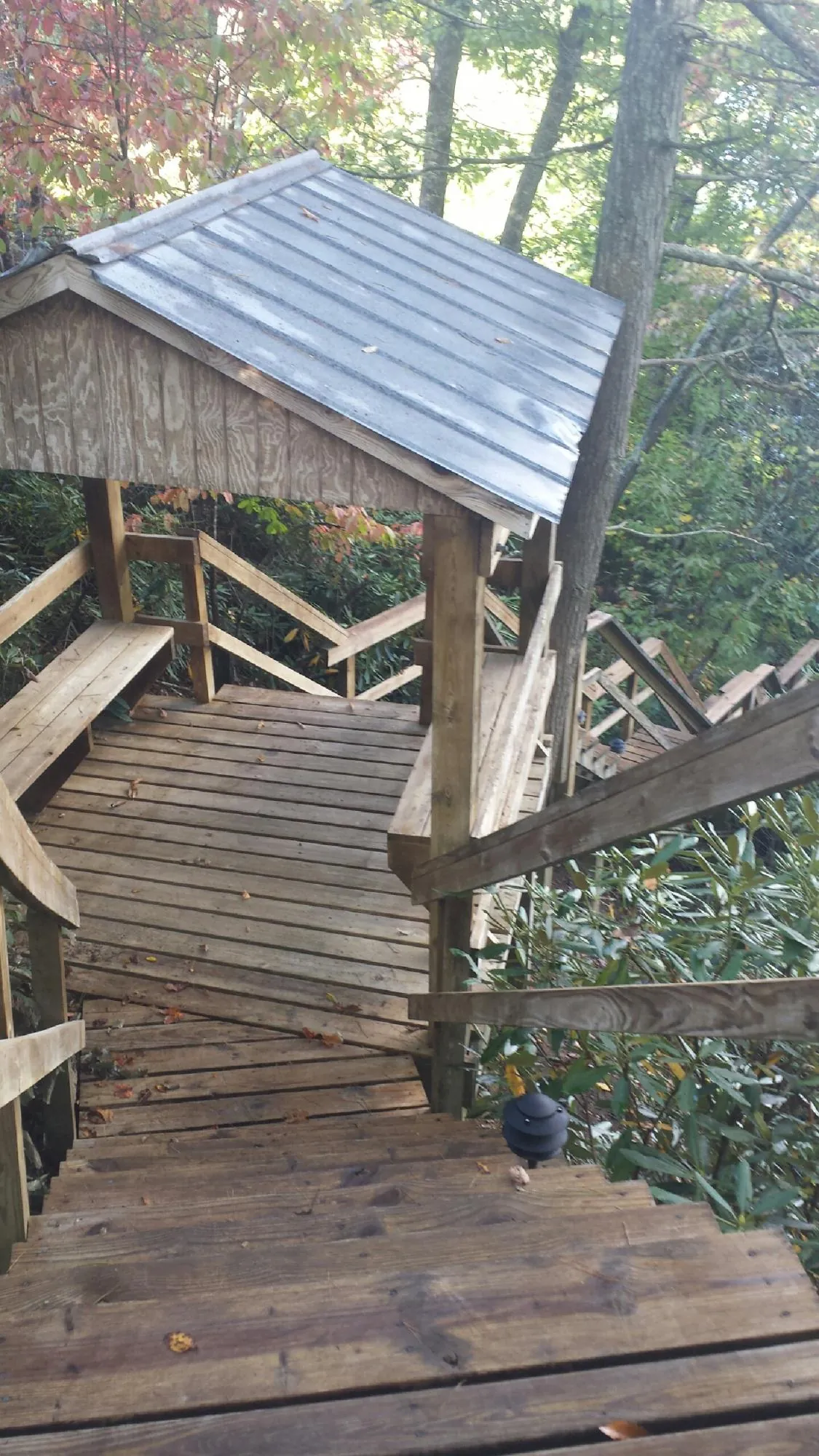 Metal roofed shelter over wooden steps on a wooded walkway — Skylight Repair & Installation work by our crew in Henryetta