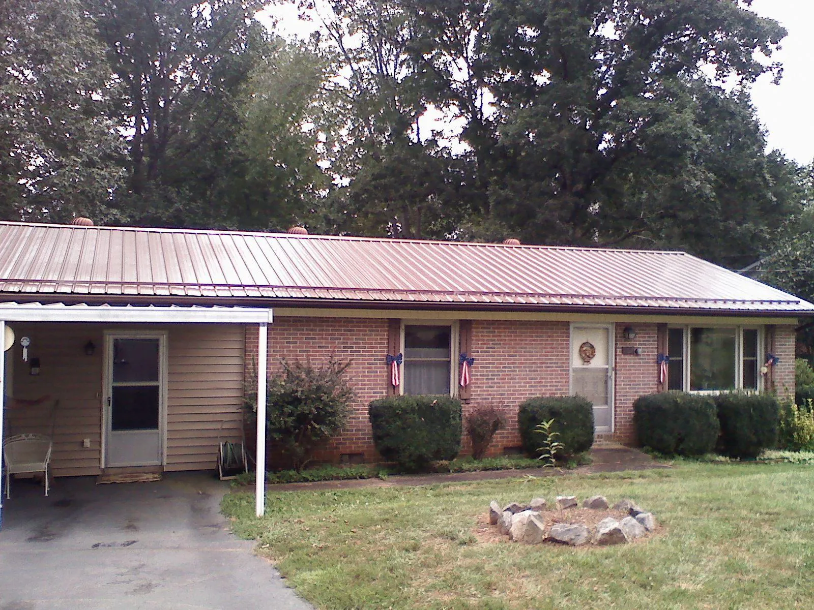 Bronze metal roof and carport on a brick ranch home — Roof Repair work by our crew in Henryetta